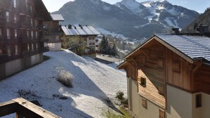 A mountainous village with wooden buildings, a snow-covered ground, and a clear sky. - Charming studio in Châtel, near center, parking included (Châtel)