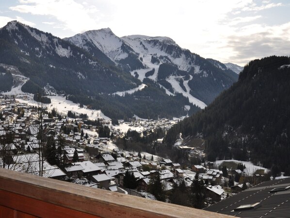 A mountain town with snow-covered houses and a view of the surrounding mountains.