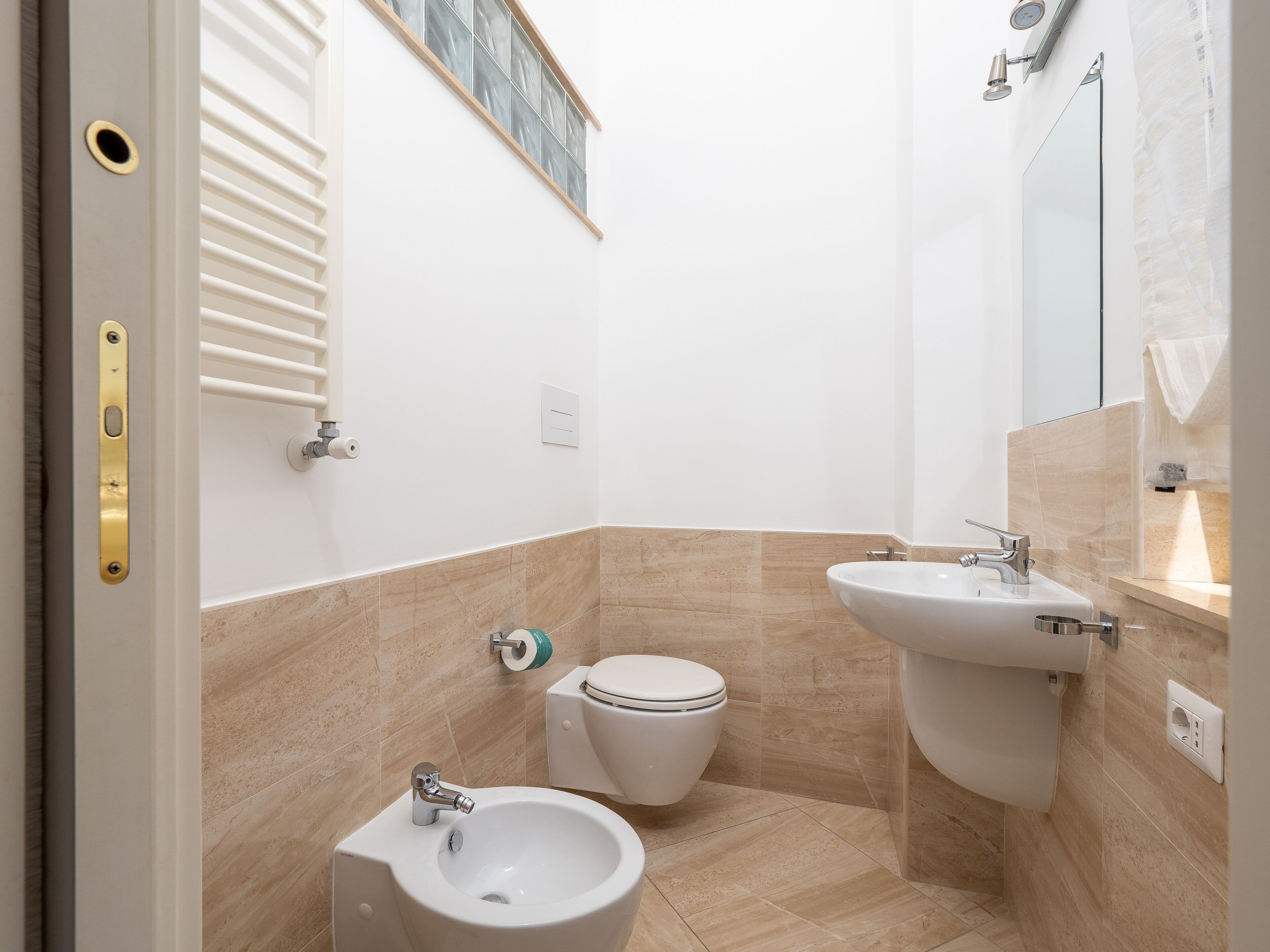 Un baño pequeño con inodoro, bidé y lavamanos.