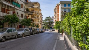 A street lined with parked cars and multi-story buildings with balconies and windows. - Parsano suite (Sorrento)