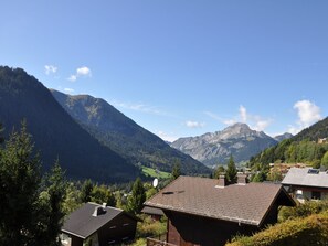A mountain village with traditional wooden houses, a clear sky, and a valley view. - Charming flat near village with parking (Châtel)