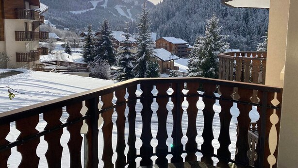 Ein Balkon mit Blick auf schneebedeckte Berge und einen klaren Himmel.