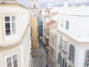Un vicolo stretto tra gli edifici, con una torre sullo sfondo.
