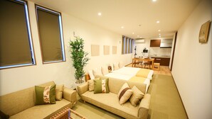 Uma sala de estar moderna com sofá, mesa de centro e área de jantar com mesa e cadeiras.