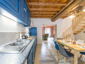 Enjoy meals in the kitchen with an oven and dining area with a wooden table.