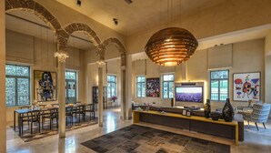 Un salón amplio con un televisor grande, muebles modernos y obras de arte en las paredes.