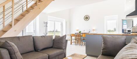 Una sala de estar moderna con un sofá, una mesa de centro y una escalera.