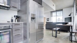 Eine moderne Küche mit Edelstahlgeräten, einer grauen Arbeitsplatte und einem minimalistischen Design.