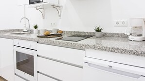 A modern kitchen with a built-in microwave, oven, and coffee maker. - Charming Apartment Next to Málaga Cathedral with A/C and Free WiFi (Málaga)