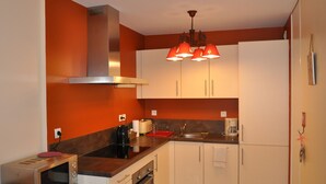 A compact kitchen with a microwave, stove, and cabinets. - 3-room apartment with large balcony, parking (La Chapelle-d'Abondance)