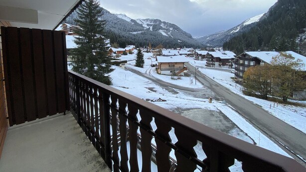 A balcony with a view of a snow-covered village and mountains. - Cozy studio near center, balcony and parking (Châtel)