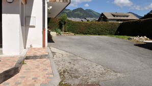 A residential area with a paved driveway leading to a house with a balcony. - Apartment with Sunny Terrace in La Chapelle-d'Abondance (La Chapelle-d'Abondance)
