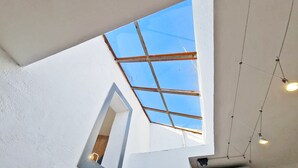 A room with a skylight, a wooden door, and hanging lights.