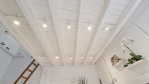 A high ceiling with exposed beams and recessed lighting.