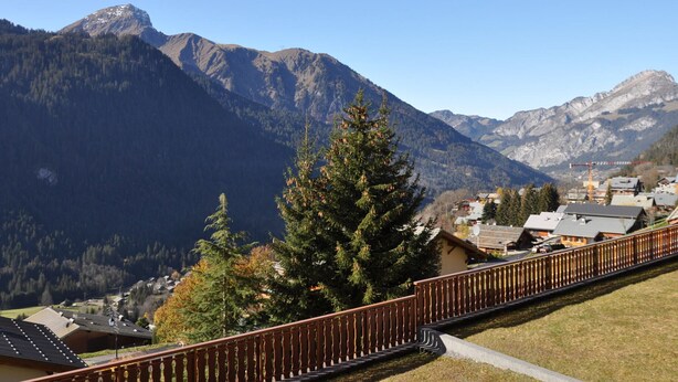 A mountain landscape with a wooden fence, houses, and a clear sky. - Charming apartment in Petit-Châtel, pets allowed (Châtel)