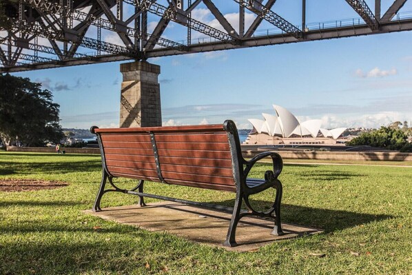 A bench in a park with a bridge and the Sydney Opera House in the background. - 2 mins walking to harbour bridge (Dawes Point)