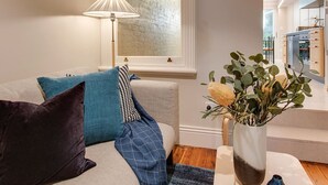 A modern living room with a sofa, cushions, a lamp, and a plant. - 2 mins walking to harbour bridge (Dawes Point)