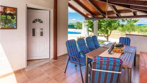 A covered patio with a pool view, outdoor seating with striped chairs, and a door leading to an interior space. - Stunning home in Bila Vlaka (Bila Vlaka)