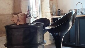A kitchen with a black chair, a wine bottle, and a pig-shaped container. - 19th Century family home with terrace & garden, ideal for 10 people. (Cindré)