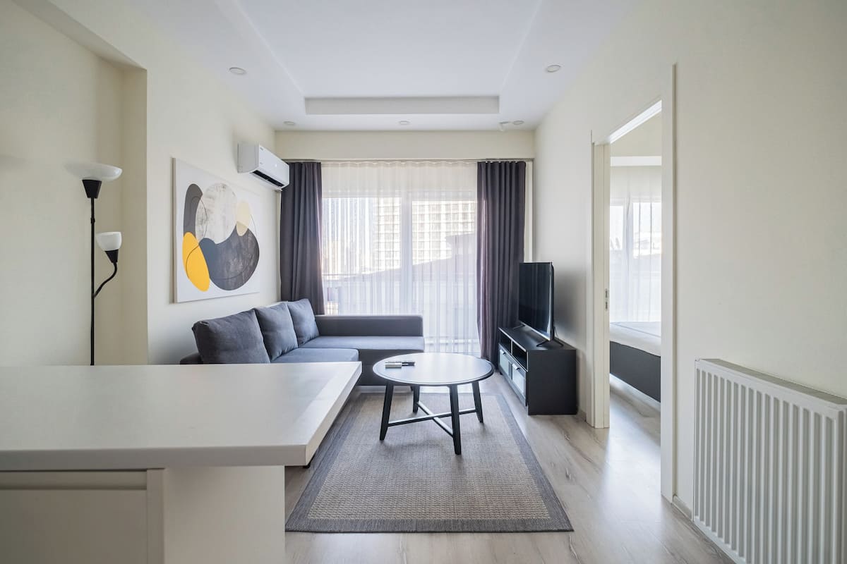 A modern living room with a sofa, a coffee table, and a TV.