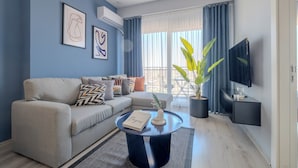 Una sala de estar moderna con un sofá gris, una mesita de centro y una planta en maceta.