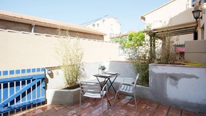 A patio with a table and two chairs, a blue gate, and a potted plant. - GregBnb - Le Lacordaire - Toulon Ouest (Toulon)