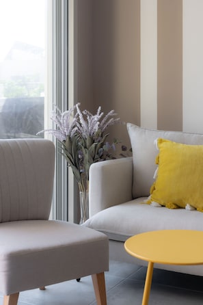 Relax in this inviting living room with a sofa, armchair, and round table.