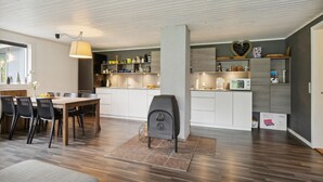 A modern kitchen with white cabinets, a built-in microwave, and a waffle maker on the counter. - 4 bedroom awesome home in Sæby (Sæby)