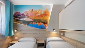 A room with two beds, a wooden headboard, a mural of a mountain landscape, and a window with curtains.