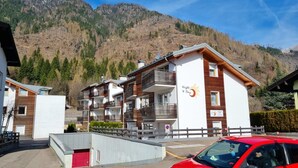 A multi-story hotel with balconies, a ski lift in the background, and a mountainous landscape. - Apartment 'Night and Day 8' with Mountain View, Balcony and Wi-Fi (Predazzo)