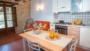 Una cocina con una mesa de comedor, sillas, estufa y lavaplatos.