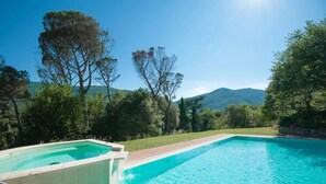 Una piscina con vistas a montañas y árboles.