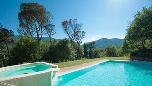A swimming pool with a clear blue water, surrounded by greenery and trees, with a mountain in the background. - Apartment "Pilari Castagnolo" with Mountain View, Shared Pool & Wi-Fi (Cortona)