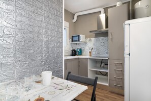 Une cuisine équipée d’un four à micro-ondes, d’une machine à café et d’un réfrigérateur.