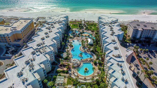 A resort with multiple buildings, a central swimming pool, and a beach. - Million$$ Panoramic Views from Wrap-Around Balcony! Free Beach Service! (Fort Walton Beach)
