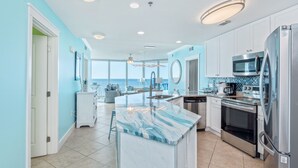 A modern kitchen with a large island, stainless steel appliances, and a view to the outside. - Million$$ Panoramic Views from Wrap-Around Balcony! Free Beach Service! (Fort Walton Beach)
