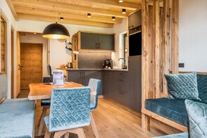 A cozy kitchen with wooden cabinets, a built-in oven, and a dining area with a table and chairs.