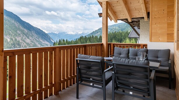 A wooden deck with a table and chairs, overlooking a mountainous landscape. - Mountain Chalet "Blosegghof Himmelblick" with Mountain View & New Whirlpool (Ratschings)