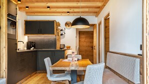 A wooden interior with a dining table, chairs, a kitchen area, and a bench. - Mountain Chalet "Blosegghof Himmelblick" with Mountain View & New Whirlpool (Ratschings)