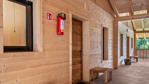 Eine Holzhütte mit Feuerlöscher, einer Bank und einer Tür zu einem anderen Raum.