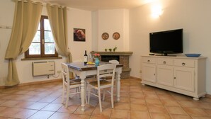 Un espace repas comprenant une table, des chaises, un téléviseur et une cheminée.