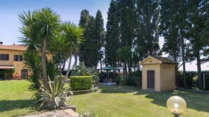Un jardin bien entretenu, agrémenté d’un kiosque, d’un petit abri de jardin et d’un lampadaire.