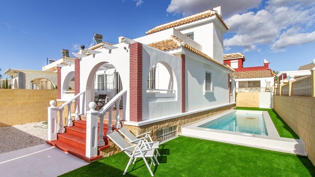 A modern house with a swimming pool, a covered patio, and a staircase leading to the entrance.
