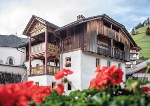 Un bâtiment traditionnel en bois, doté de balcons et d’une façade blanche.