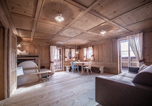 L’intérieur d’une cabane en bois comprend un coin repas, un canapé et un banc.