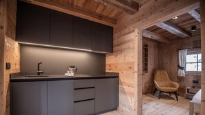 Een moderne keuken met donkere kastjes, een aanrecht en een koffiezetapparaat.