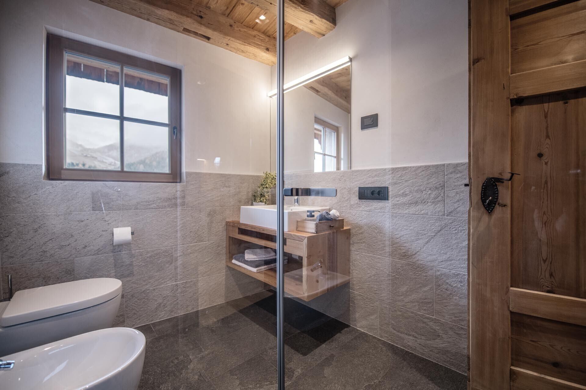 A modern bathroom with a toilet, sink, and shower area.