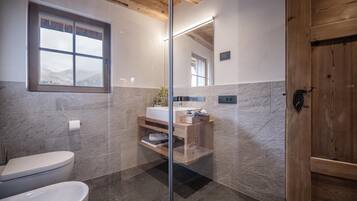 A modern bathroom with a toilet, sink, and shower area.