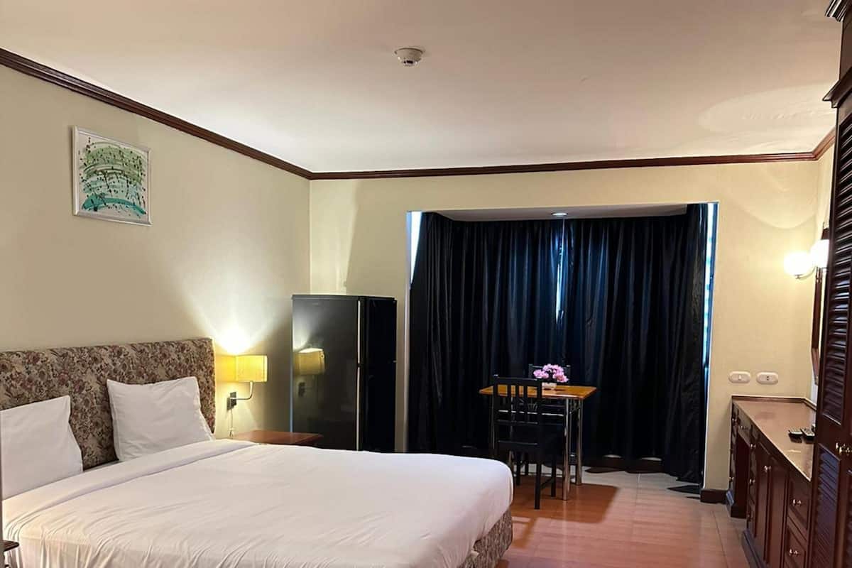 A hotel room with a bed, a desk, and a wardrobe.