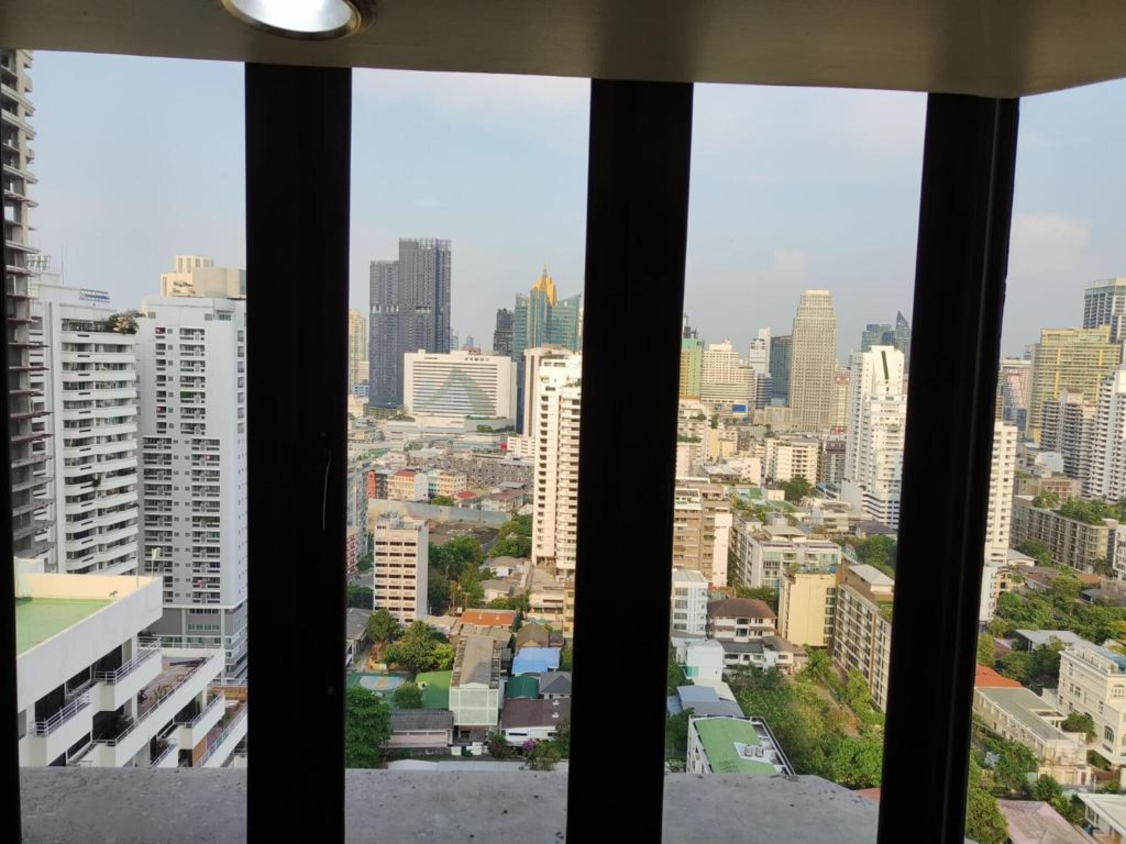 Un immeuble de grande hauteur, doté de nombreux étages, de grandes fenêtres et offrant une vue sur un paysage urbain composé de différents bâtiments.